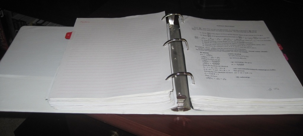 Photo of a 3-inch binder filled with homework assignments